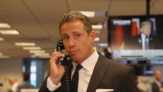 CNN anchor Chris Cuomo stands in an office making a telephone call.