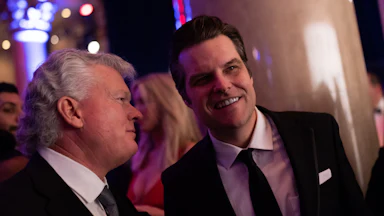 Matt Gaetz smiles while conversing with another person.