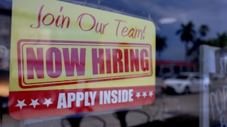 Now Hiring sign on a window