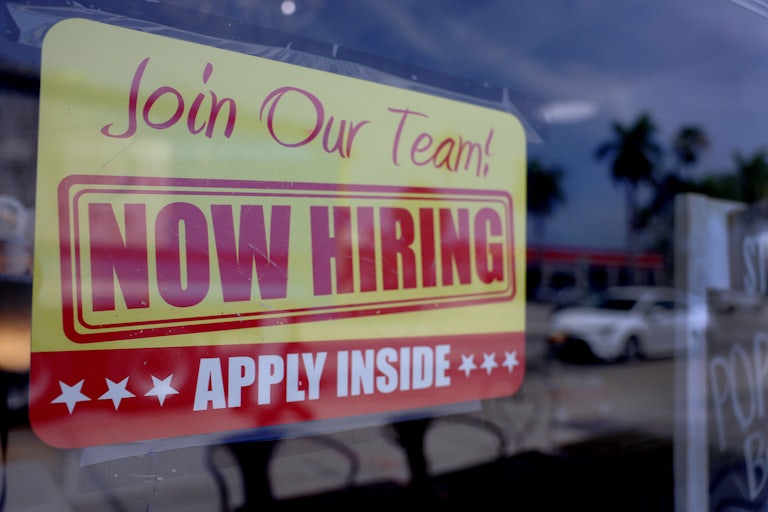 Now Hiring sign on a window
