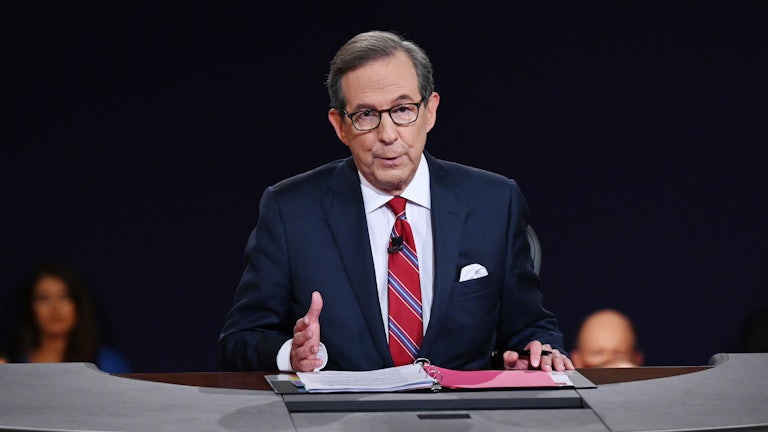 Fox News' Chris Wallace sits at a desk during a presidential debate.