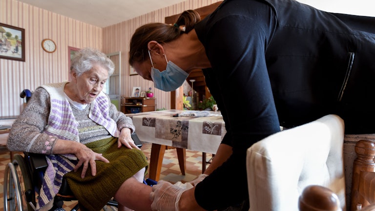 A nurse examines a woman's leg.