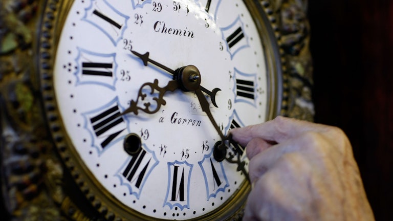 A man sets the clock back to mark the end of Daylight Saving Time.
