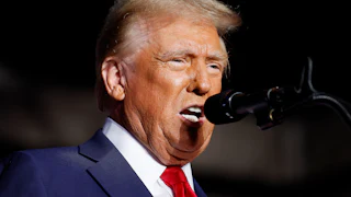 Donald Trump speaking into a mic