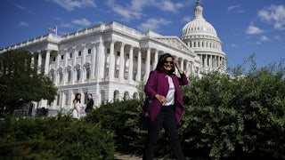 A smiling Rep. Pramila Jayapal arrives for a news conference with fellow members of the House Progressive Caucus ahead of the vote on the Inflation Reduction Act.