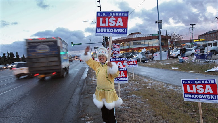 Darlene Heckler, an Inupiaq Native American, greets motorists while supporting U.S. Senator Lisa Murkowski for reelection in Anchorage, Alaska. 