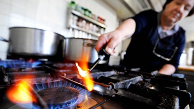 A person lights a gas stove.