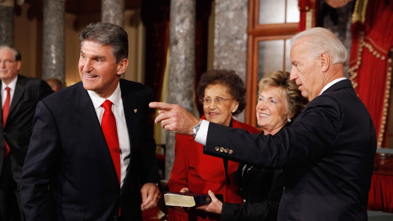 Joe Biden gestures alongside Senator Joe Manchin.