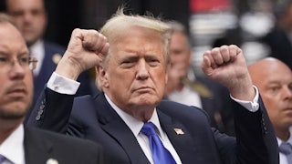 Trump raises both fists.