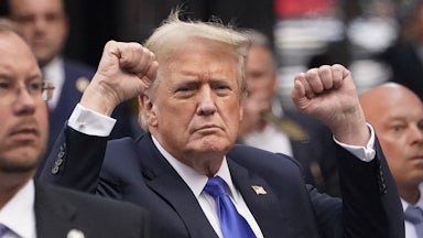 Trump raises both fists.