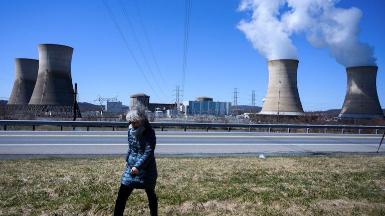 A woman walks past the nuclear plant on Three Mile Island.