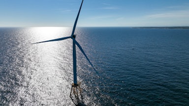 A wind turbine rises up out of the Atlantic Ocean.