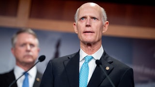 Senator Rick Scott speaking at a lecturn (he looks weird)