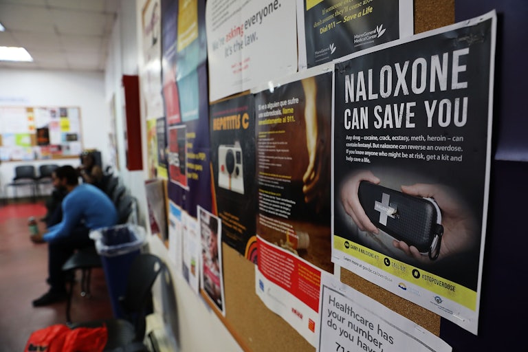 A sign for Naloxone hangs on a wall