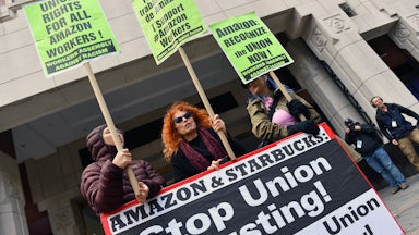 Three demonstrators hold signs supporting unionization of Amazon workers.