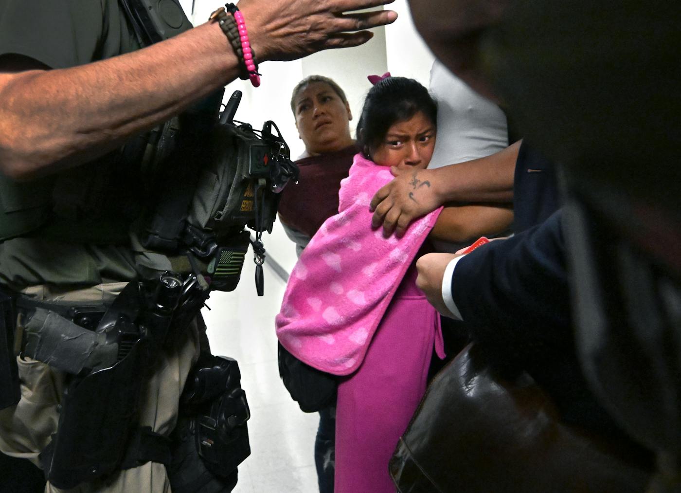 A photo of a child clung to her father as ICE agents and federal officers detained him in Manhattan in July 2025.