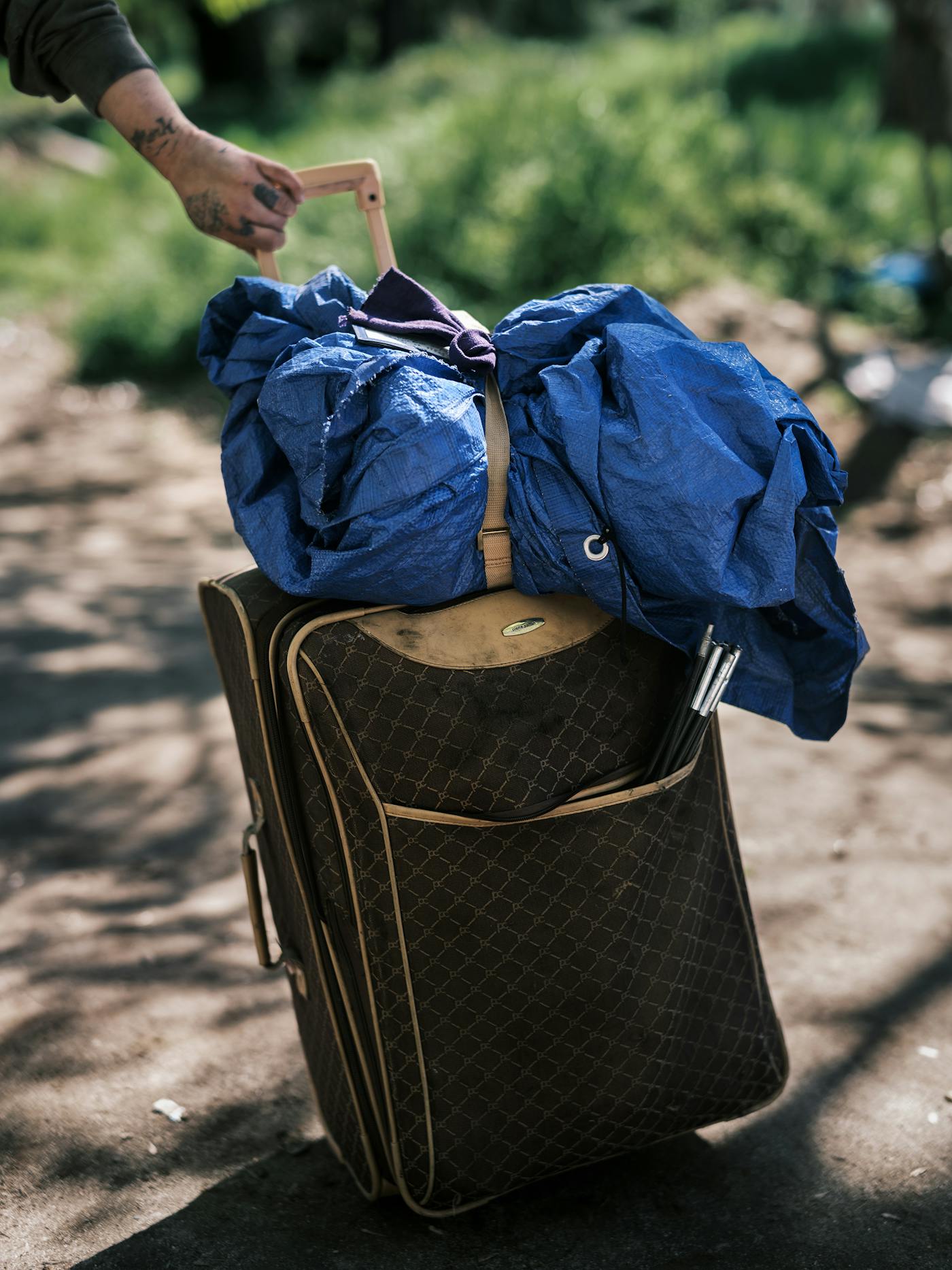 At Baker Park a person pulls a suitcase that holds all their belongings