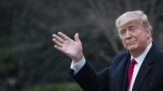 President Donald Trump waves at a camera.