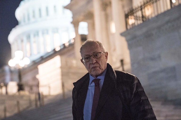 Alan Dershowitz purses his lips as he stands in front of the Capitol