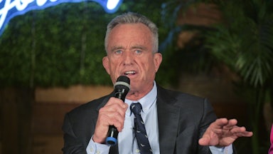 RFK Jr. holds a microphone and speaks.
