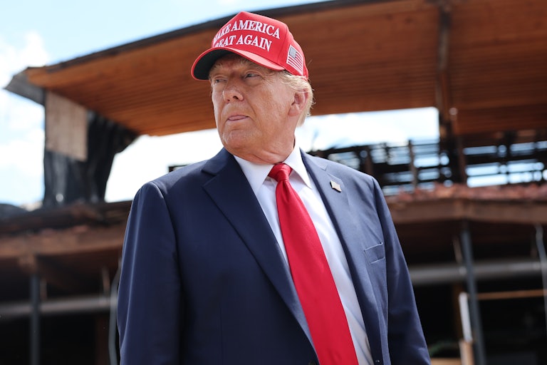 Donald Trump stands and sticks his tongue out slightly