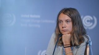 Greta Thunberg leans her head on her hand. 