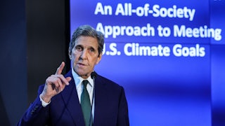 John Kerry holds up a finger while speaking.