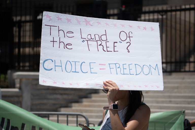 Sign reads: "The Land of the free? Choice = freedom"