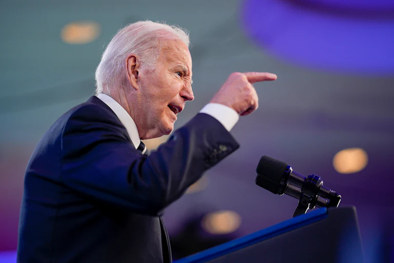 Joe Biden gestures as he speaks into microphones