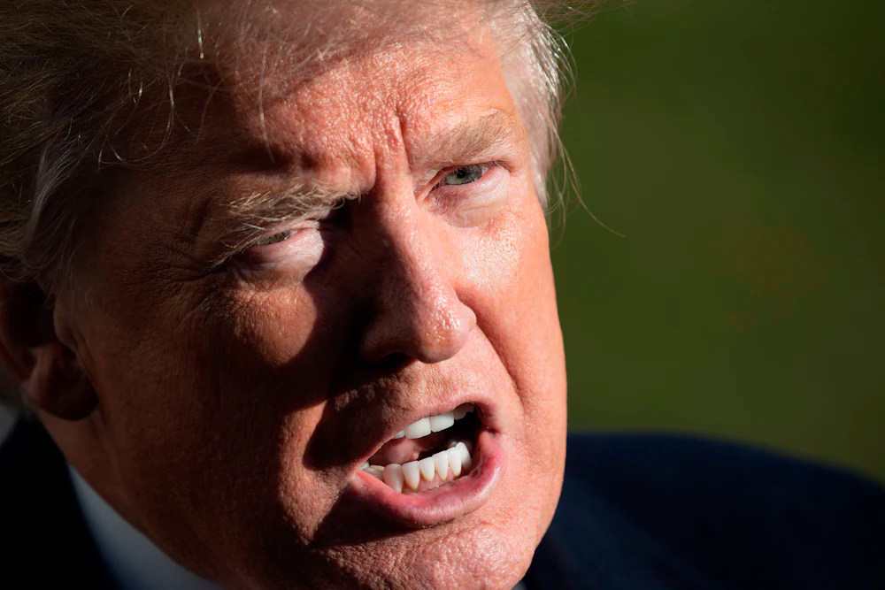 Donald Trump scowls as he speaks to reporters.