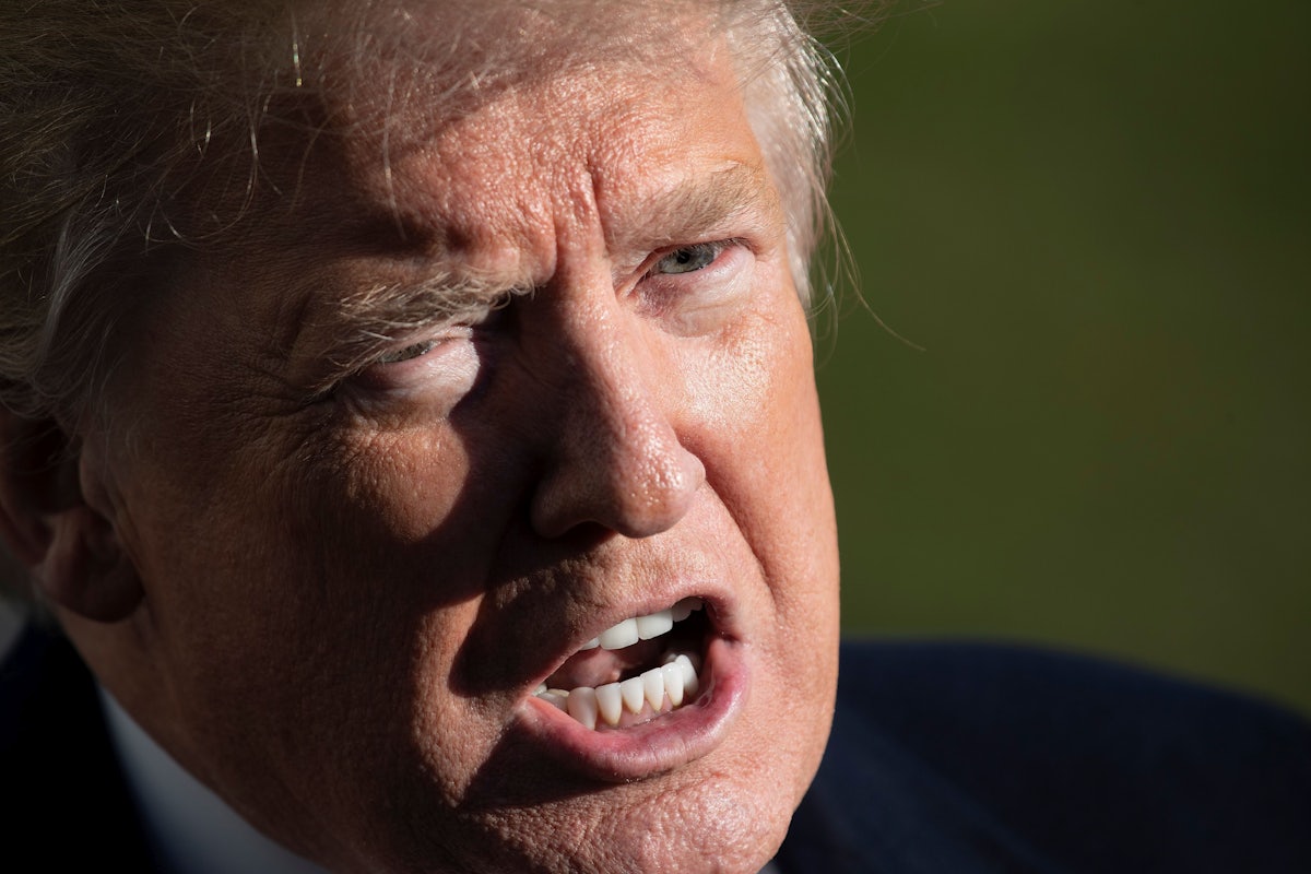 Donald Trump scowls as he speaks to reporters.