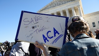 A demonstrator holds a sign in front of the US Supreme Court in support of the Affordable Care Act.