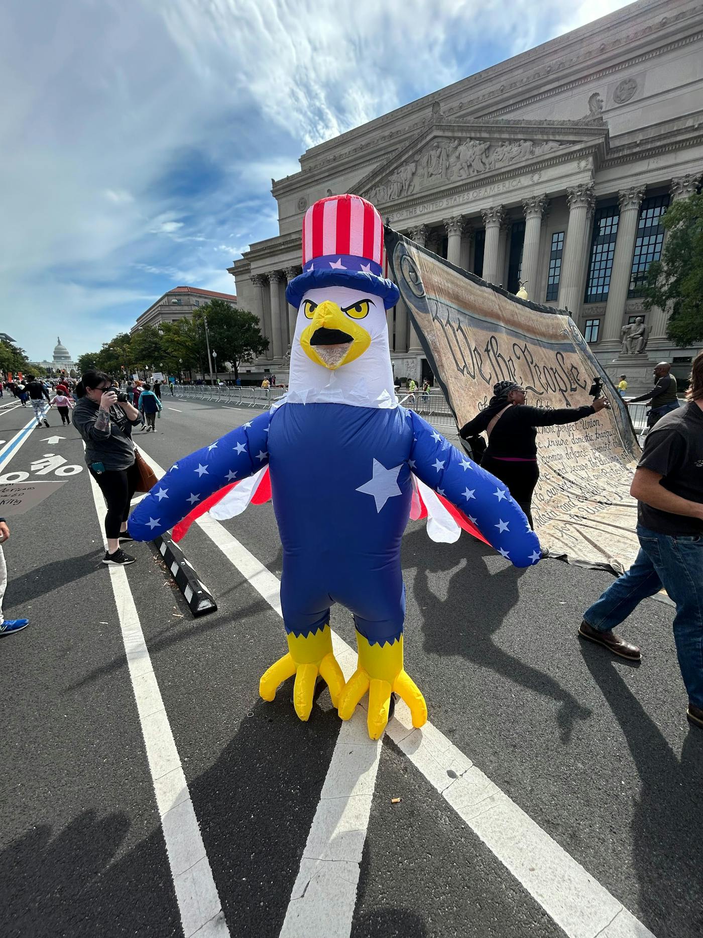 An inflatable eagle stands in the road in front of a large printout of the Constitution