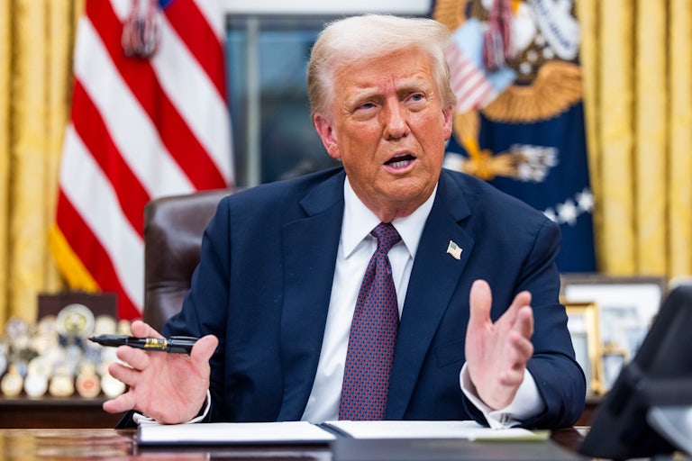 Donald Trump gestures and speaks while signing executive orders