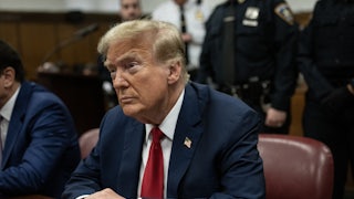 Donald Trump sits with his hands folded