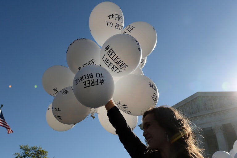 A protester holds balloons calling for religious freedom outside the Supreme Court.