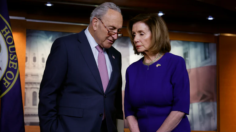 Senate majority leader Chuck Schumer and House Speaker Nancy Pelosi confer with each other.