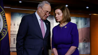 Senate majority leader Chuck Schumer and House Speaker Nancy Pelosi confer with each other.