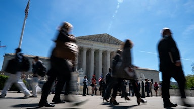 People walk in front of the Supreme Court building.