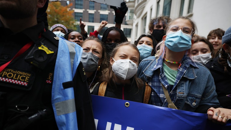Climate protesters chant while masked.