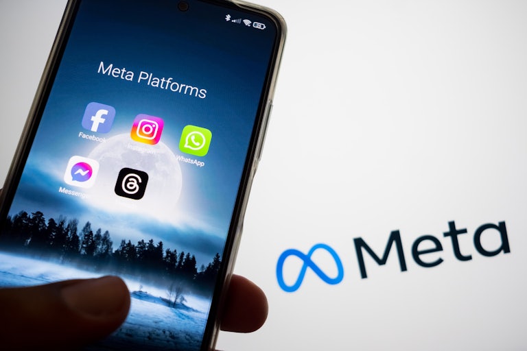 Meta's many app platforms are displayed on a smartphone screen, and the Meta logo is appearing in the background.