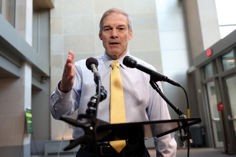 Jim Jordan speaks at a lectern with two mics. He makes a hand gesture and looks down.