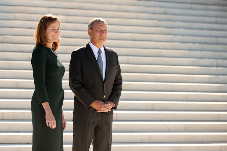 Chief Justice John Roberts and Justice Amy Coney Barrett stand on the steps of the Supreme Court.