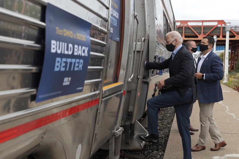 Joe Biden gets on an Amtrak train sporting his "Build Back Better" campaign slogan.