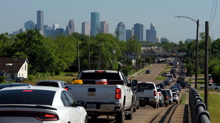 Cars wait in a line on a highway.