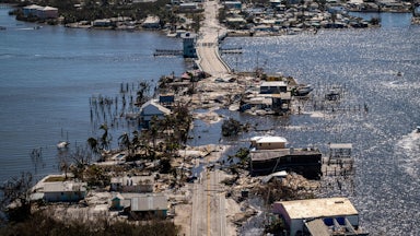 A road and neighborhood appear to sink into the sea in an image taken after Hurricane Ian.