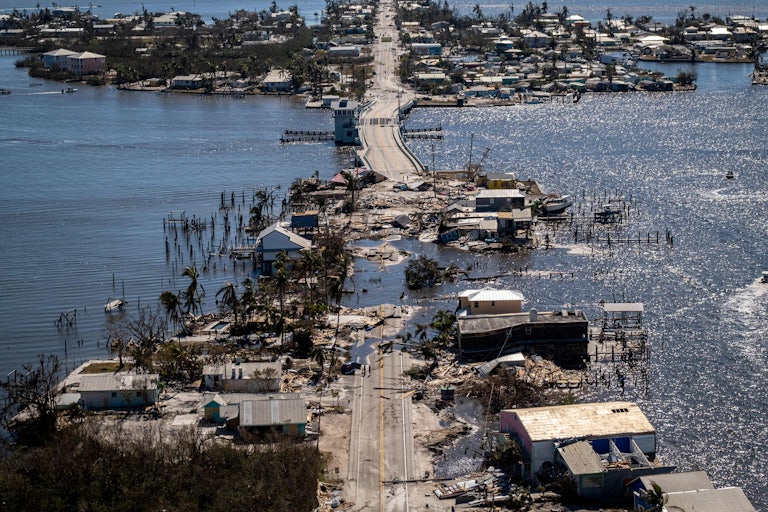 A road and neighborhood appear to sink into the sea in an image taken after Hurricane Ian.