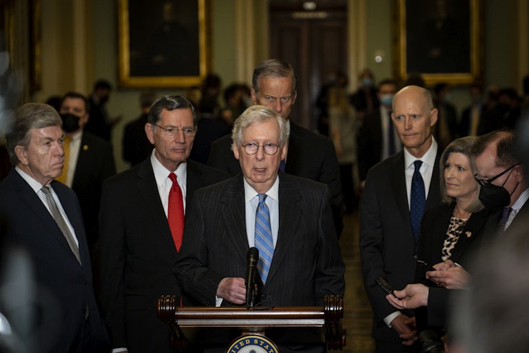 Senate Minority Leader Mitch McConnell stands at a lectern flanked by his Republican colleagues.