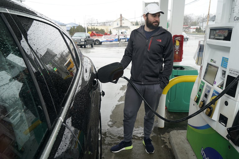 A man pumps gas at a service station in New York.