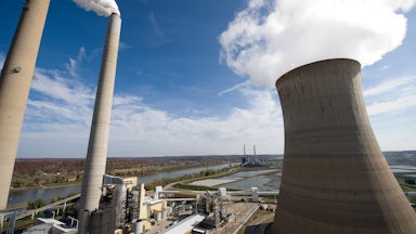 Cooling towers emit steam over an industrial landscape.